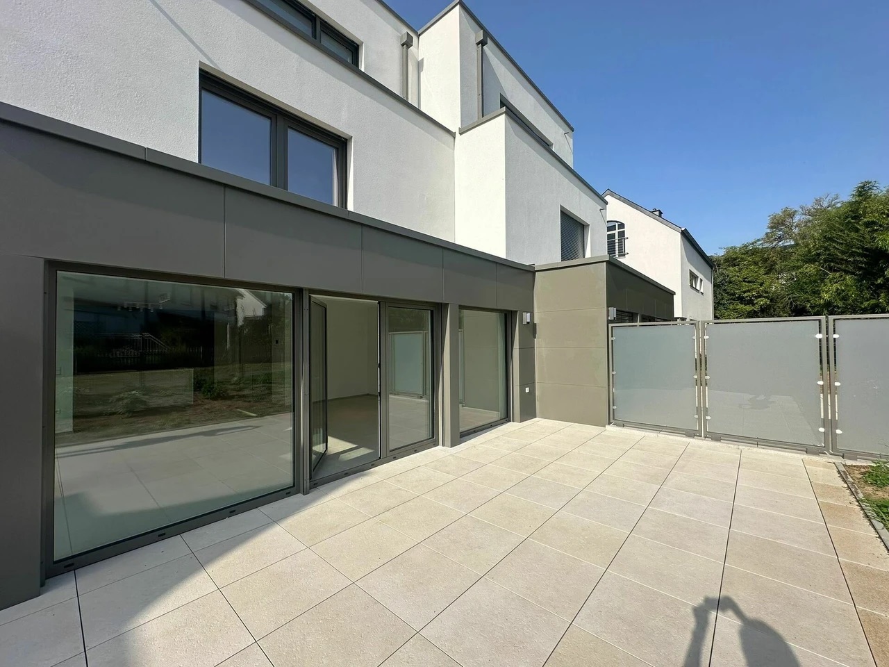 Terrasse en carrelage avec accès direct au salon et au jardin